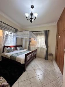 a bedroom with a large bed with a canopy at GRACE ViLLA in Kitende