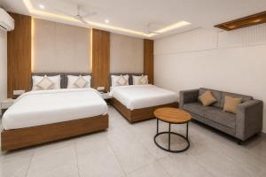 a hotel room with two beds and a couch at Bungalow Seven Mount Abu in Mount Ābu