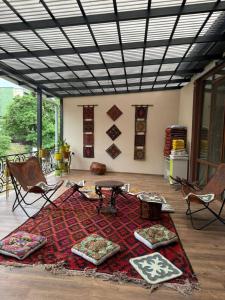 a room with a table and chairs and a rug at Sultan Saray in Osh