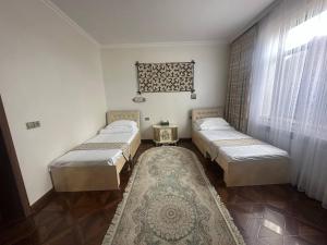 a room with three beds and a rug at Sultan Saray in Osh