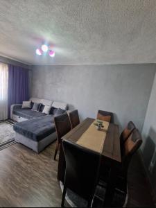 a bedroom with a bed and a table and chairs at Modern Panoramic View Apartament in Sighetu Marmaţiei