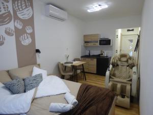 a room with a bed and a kitchen with a table at Pogácsás Apartman III in Tokaj