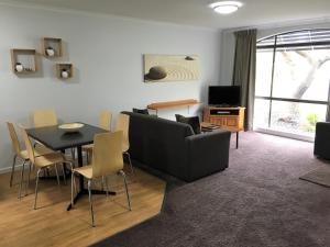 a living room with a couch and a table and chairs at Barwon Valley Lodge in Geelong