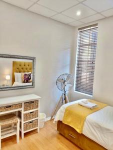 a bedroom with a bed and a fan at The Skinny Expat - Paarl - Self Catering Apartment in Paarl