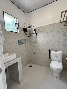 a bathroom with a toilet and a sink at SabinaGateway Suites in Panglao Island