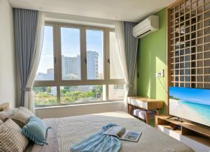 a bedroom with a bed and a large window at Seaflow Staycation in Danang