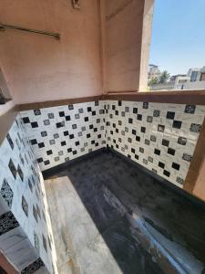 a bathroom with a tiled floor and a window at Castel Rock in Nashik