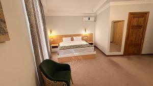 a hotel room with two beds and a chair at The Garden of Shaherezade in Bukhara