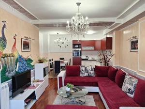 a living room with a red couch and a kitchen at Twins Apartments in Čačak