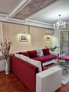 a living room with a red couch and a table at Twins Apartments in Čačak