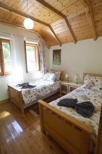 a bedroom with two beds and a wooden ceiling at Kulla e Andrrave in Ducaj +29 photos