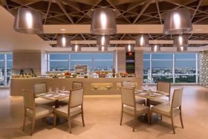 达卡Crowne Plaza Dhaka Gulshan by IHG的一间带桌椅的用餐室和一间酒吧