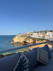 a blue couch on a balcony overlooking the ocean at Bela Vista Suites in Carvoeiro +5 photos