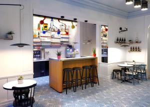 a restaurant with two tables and a bar with stools at Vintage Hotel Brussels in Brussels