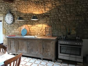 uma cozinha com um fogão e uma parede de pedra em Le Vieux Château de Saint Martin-Lars em Saint-Martin-Lars-en-Sainte-Hermine