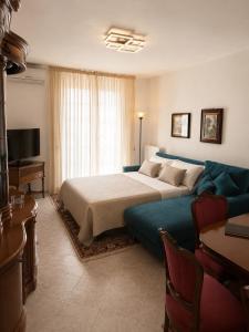 a bedroom with a large bed and a blue couch at Lo Zio Vito in Porto San Giorgio
