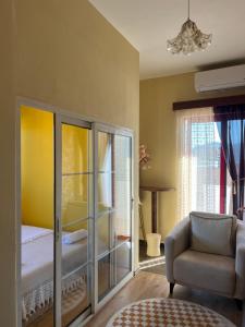 a living room with a chair and a bedroom at City Centre Rooms 4R in Shkodër