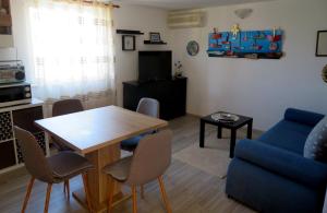 a living room with a table and a blue couch at Mali raj in Stara Novalja