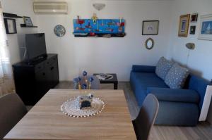 a living room with a table and a blue couch at Mali raj in Stara Novalja +1 photo