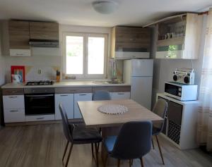 a kitchen with a table and chairs in a kitchen at Mali raj in Stara Novalja
