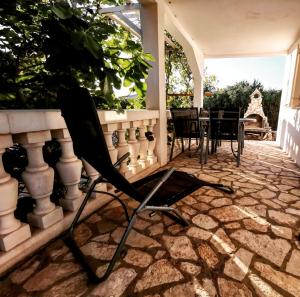 a chair sitting on a patio with a table at Mali raj in Stara Novalja