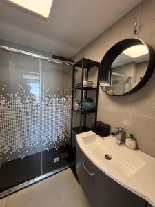 a bathroom with a shower and a sink and a mirror at Bela Vista Suites in Carvoeiro