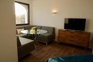 a living room with a couch and a table and a tv at Bela Vista Suites in Carvoeiro