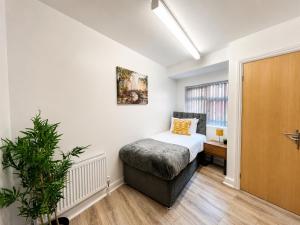 a small bedroom with a bed and a window at Sangha House - Ensuite Rooms with Shared Kitchen Facilities in Leicester