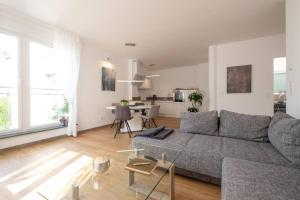 a living room with a gray couch and a table at eifel5starIV Burgfriedstraße in Daun
