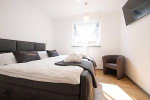 a bedroom with a large bed and a chair at eifel5starIV Burgfriedstraße in Daun