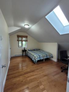 a attic bedroom with a bed and a window at Private Room in Guest House, Near the New Oakridge Mall & Transit - Near Langara 49th Station in Vancouver