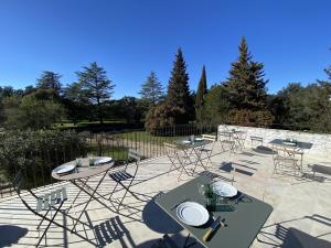 a patio with tables and chairs on a patio at O Mas de Meze in Uzès +9 photos