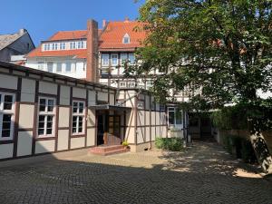 a white and black building with a tree at Hotel Goldene Krone in Goslar
