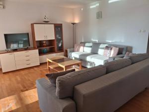 a living room with a couch and a tv at Villa Fontana 2 in Sukošan