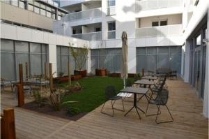 a patio with tables and chairs in front of a building at Studio récent avec terrasse Clim Airbus Aéroport in Colomiers