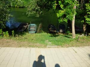 a shadow of a person taking a picture of boats at Pogácsás Apartman III in Tokaj