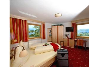 a hotel room with a bed and a suitcase at Haflingerhof in Fiss