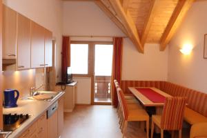 a kitchen with a table and a dining room at Haflingerhof in Fiss
