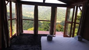 a bedroom with a large window with a view of the mountains at Trekker's Lodge in Matale