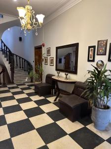 a living room with a checkered floor and a chandelier at The Exclusive House in Peshawar