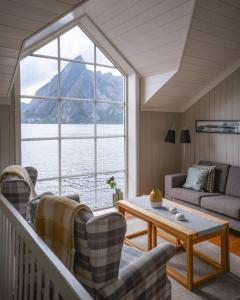 a living room with a view of the water at Reinefjorden Sjøhus in Reine