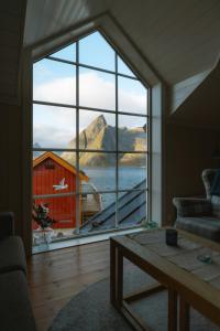 a room with a large window with a view of a barn at Reinefjorden Sjøhus in Reine