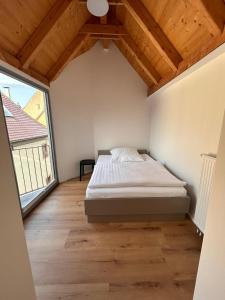 a bedroom with a bed and a large window at Platzl am Malteser in Amberg