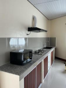 a kitchen with a sink and a microwave on a counter at SabinaGateway Suites in Panglao Island +14 photos
