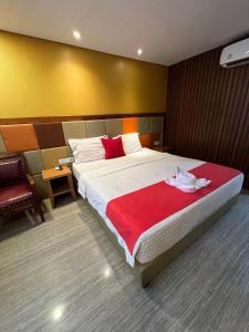 a bedroom with a large bed with a red blanket at Benhas Hotel Bukittinggi in Bukittinggi