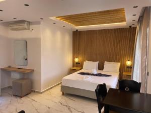 ein Schlafzimmer mit einem Bett, einem Schreibtisch und einem Tisch in der Unterkunft Acti Plaka Hotel in Plaka