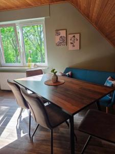 a dining room with a wooden table and chairs at Fuchs & Hase in Uplengen