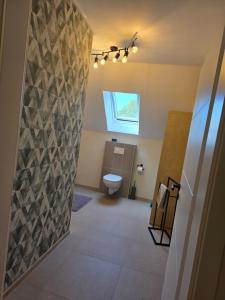a bathroom with a toilet and a window at Fuchs & Hase in Uplengen
