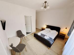 a bedroom with a bed and two chairs in it at Casa ZUGO in Borsec