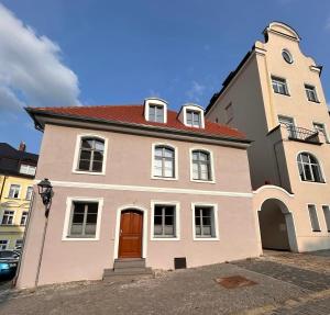 a large house with a red door on a street at Platzl am Malteser in Amberg
